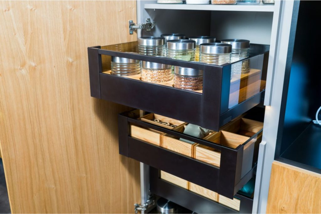 Pull-out pantry shelves full of dried food in airtight glass containers