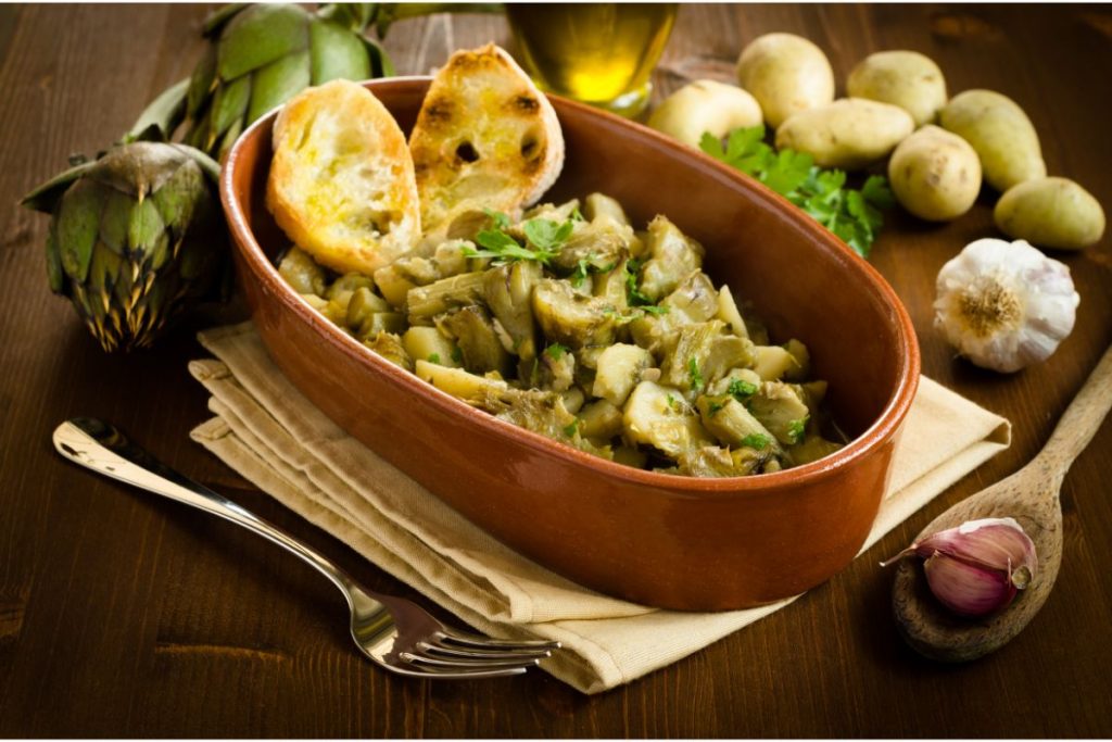 Bowl with stewed artichokes, potatoes, and garlic