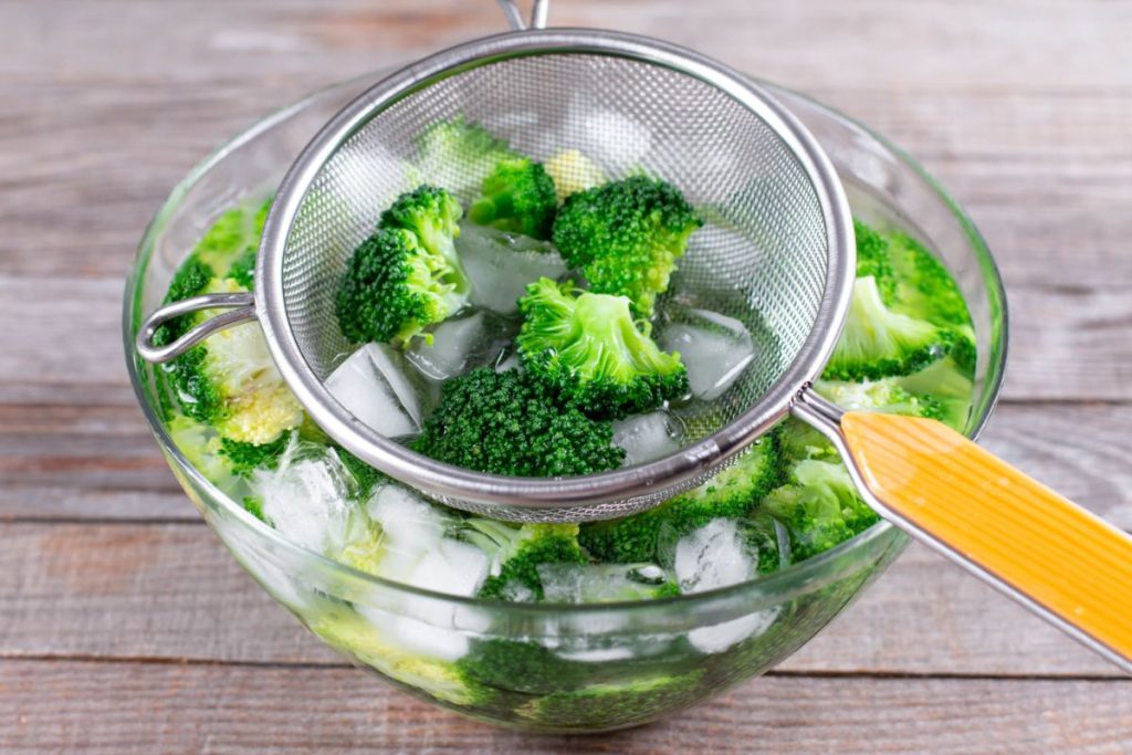 Placing broccoli in a bowl of ice water