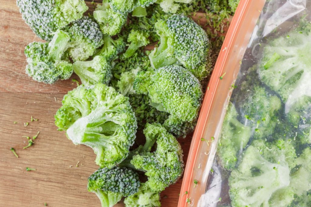 Frozen broccoli florets being poured out of freezer bag