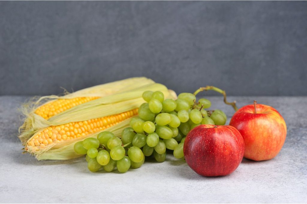 Fresh grapes, apples, and corn