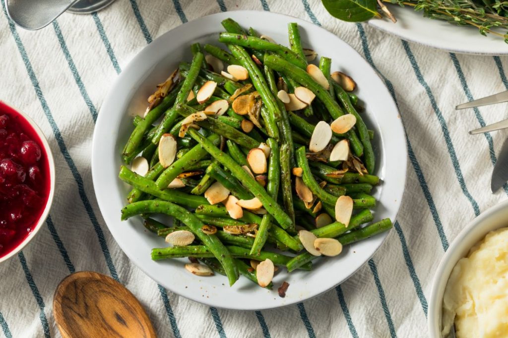 Rehydrated green beans tossed with almonds in a white bowl