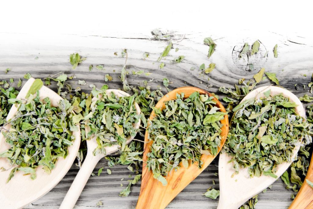 Dried herbs in wooden spoons