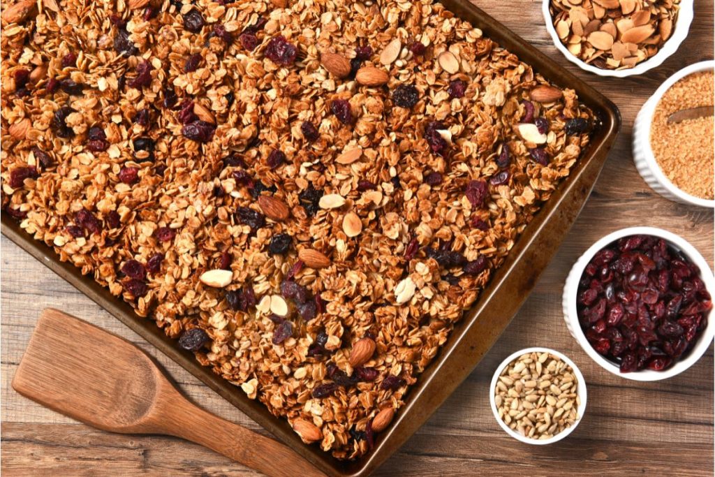 Sheet tray of granola with dried cranberries sprinkled on top