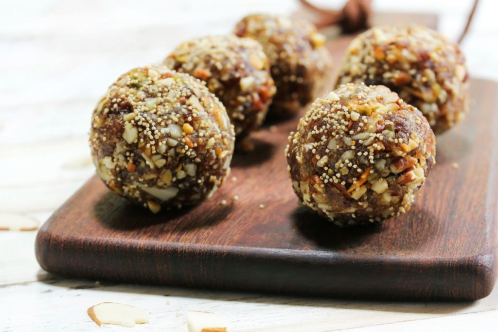 Balls of dried dates mixed with chopped nuts, seeds, and vegetables