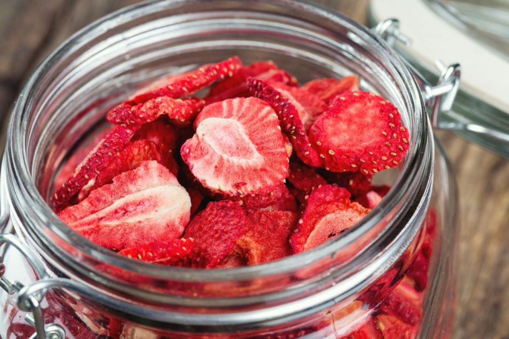 Glass jar filled with freeze-dried strawberry slices.