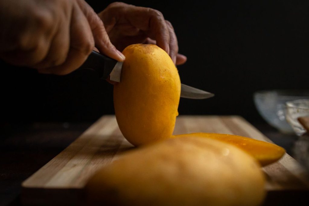 Slicing a mango along the length