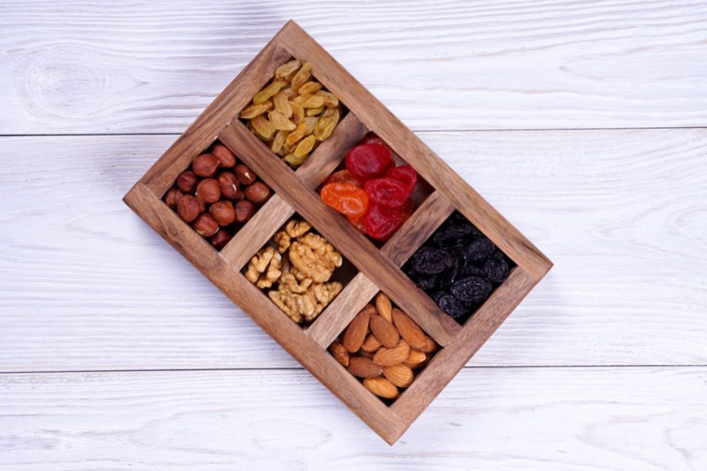 Wood box with dividers and dried fruit and nuts separated into each compartment