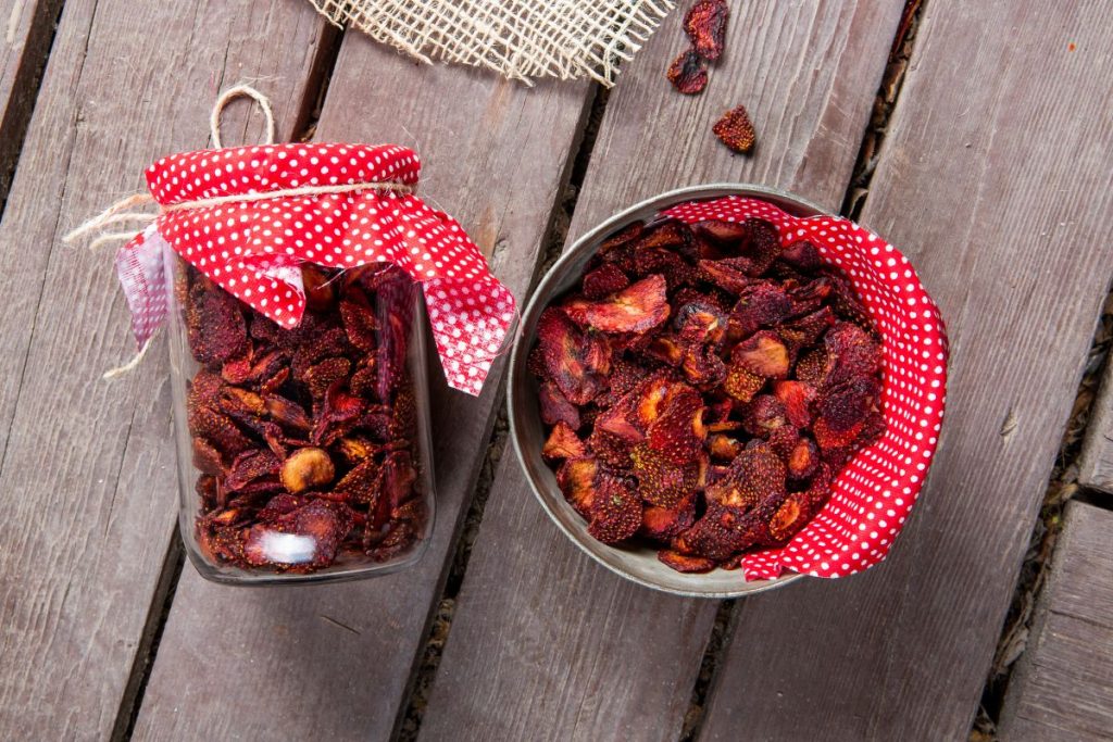 Sun-dried strawberries in a closed Mason jar and in an open bowl