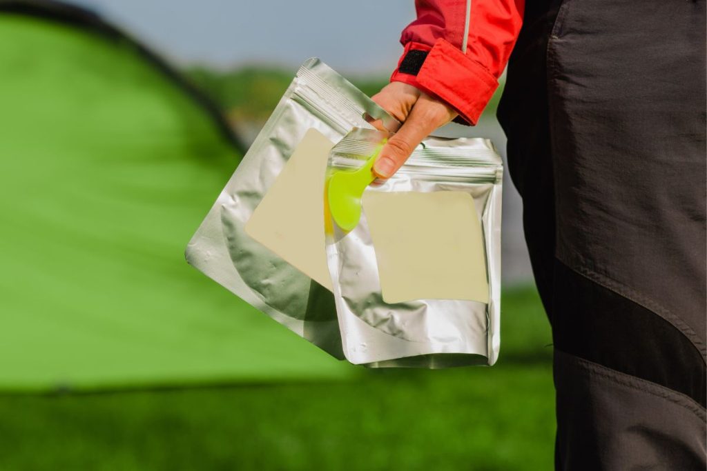 Silver Mylar food bags carried by camper towards a tent
