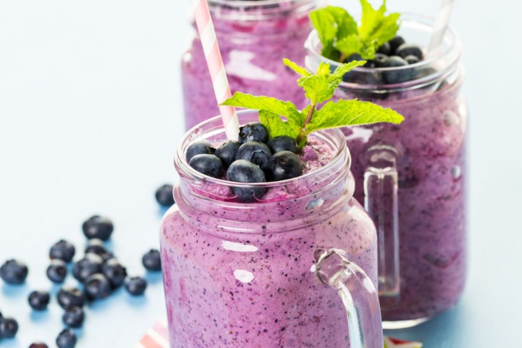 Blueberry smoothie in a glass Mason jar with handle