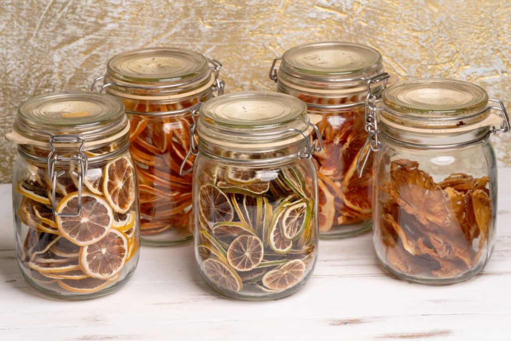 Different kinds of dried citrus slices in large mason jars