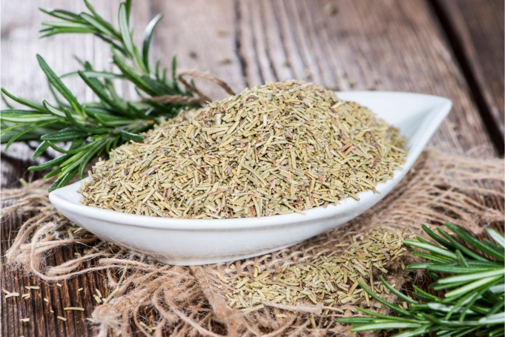 Dried rosemary leaves in a white bowl