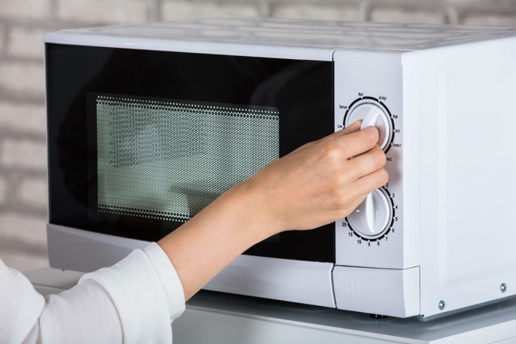 Woman setting temperature on microwave