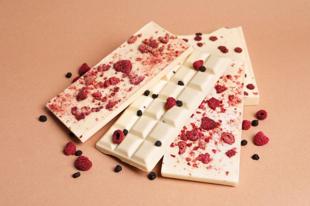 White chocolate bars covered in dried raspberries 