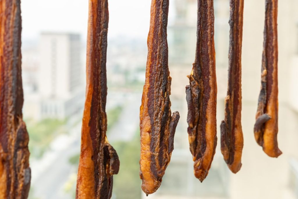 Dried bacon strips hanging in the air