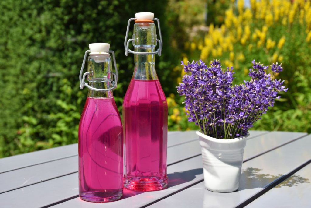 Lavender simple syrup in jars outside on table