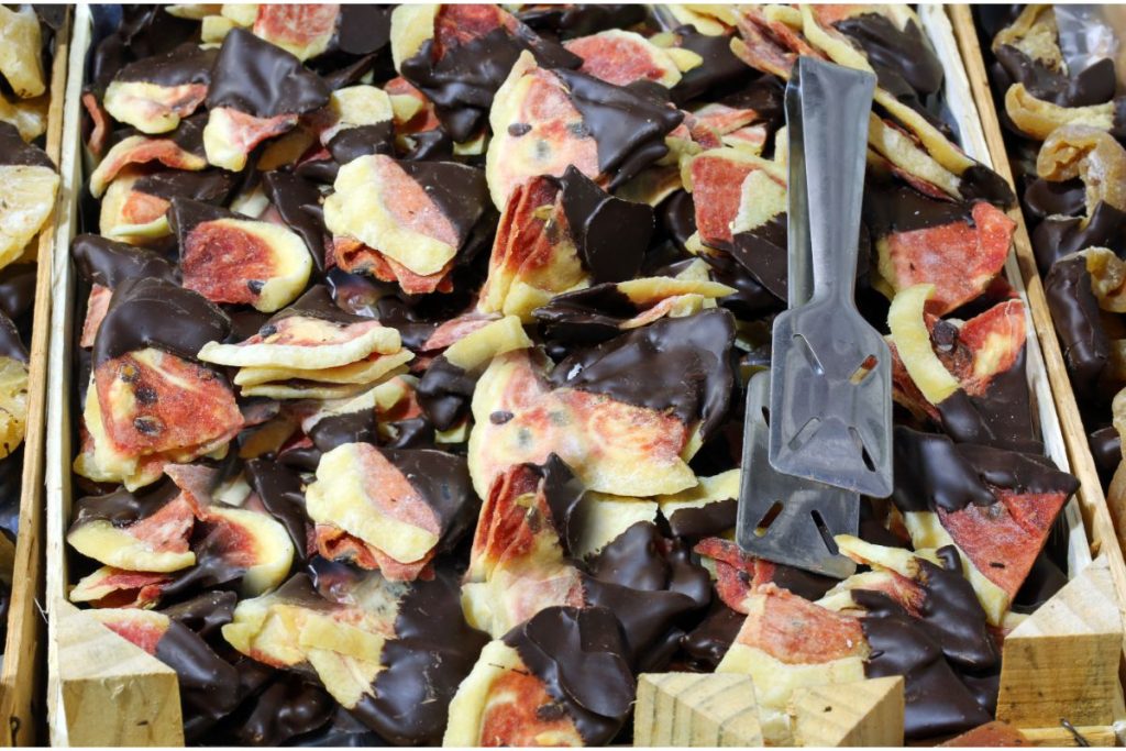 Grocery store bin full of chocolate dipped dried watermelon pieces