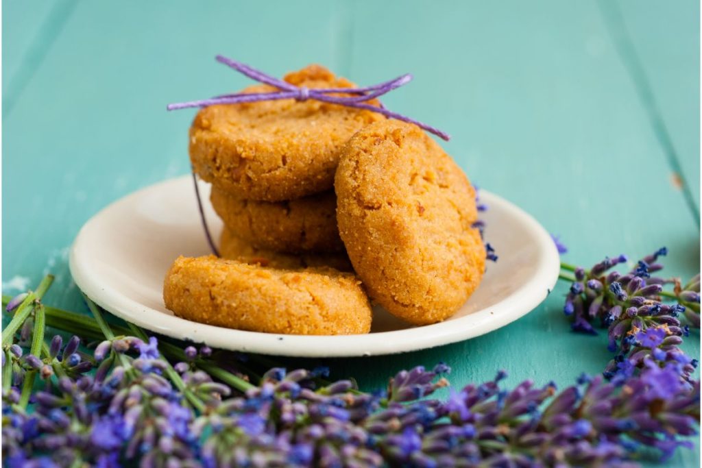 Plate of golden brown cookies surrounded by lavender
