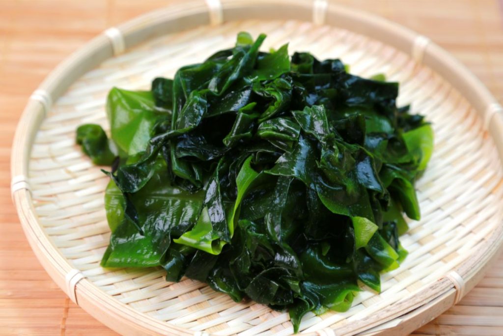 Rinsed Wakame seaweed on a woven plate