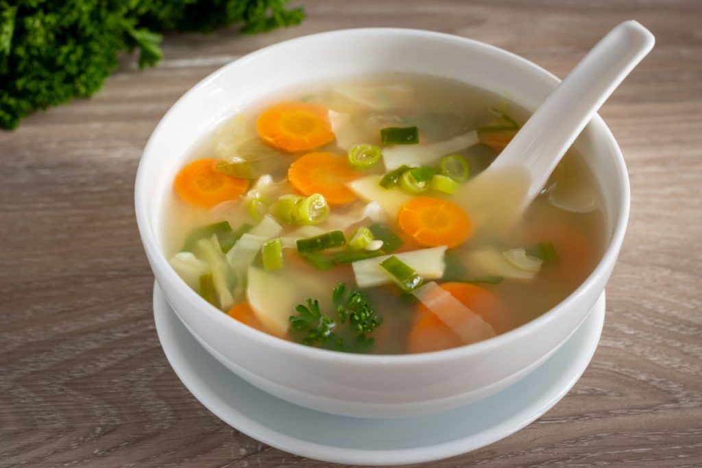 Bowl of vegetable soup in clear broth